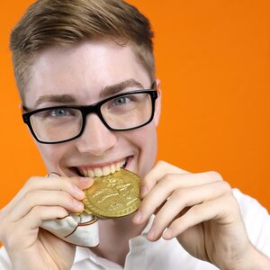 Junger Mann Beißt in eine Medaille